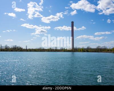 Alte Heizungsanlage Kamin. Ein Industriekamin gegen einen leicht bewölkten Himmel. Stockfoto