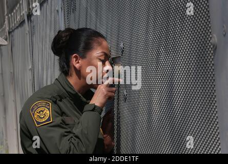 KEIN FILM, KEIN VIDEO, KEIN Fernsehen, KEIN DOKUMENTARFILM - Border Patrol Agent Wendy Lee schaut durch eines der in den Sekundärzaun geschnittenen Sichtportale, um am 9. Mai 2016 bei San Diego einen freien Blick auf die andere Seite zu bekommen, Calif. Die Instandsetzung der Schnitte im Grenzzaun ist eine tägliche Arbeit des Jahres. Foto von Peggy Peattie/San Diego Union-Tribune/TNS/ABACAPRESS.COM Stockfoto