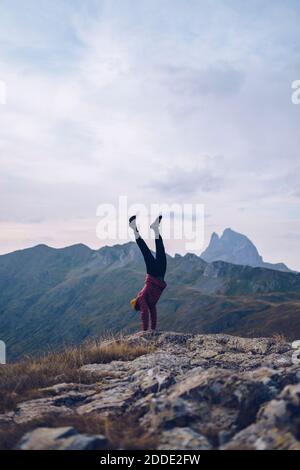 Junger Mann mit Handstand auf dem Berg um Ibones von Anayet Stockfoto