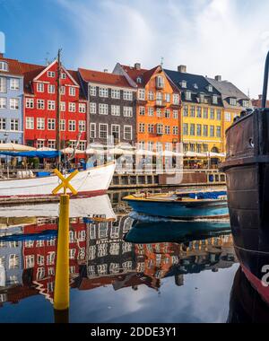 Dänemark, Kopenhagen, Boote liegen entlang Nyhavn Promenade mit Reihe von historischen Stadthäusern im Hintergrund Stockfoto