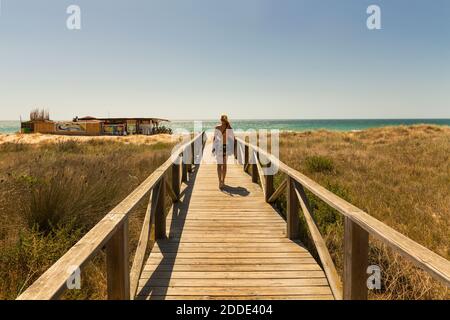 Frau, die am Strand entlang geht Stockfoto