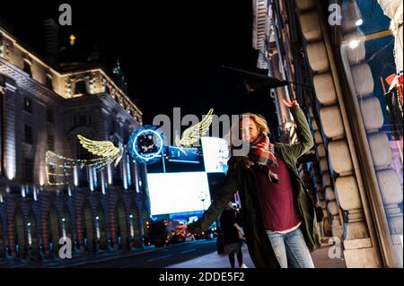 Unbeschwerte Frau tanzt während der Weihnachtszeit in der Regent Street in London, Großbritannien Stockfoto
