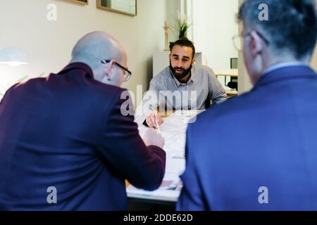 Geschäftsleute diskutieren über Blaupause auf dem Tisch im Büro Stockfoto