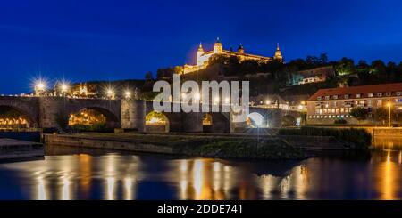 Deutschland, Bayern, Würzburg, beleuchtete Alte Mainbrücke bei Nacht mit Festung Marienberg im Hintergrund Stockfoto