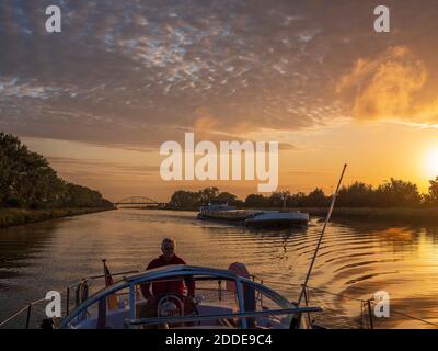 Mann Segelboot entlang Juliana Kanal bei Sonnenaufgang Stockfoto