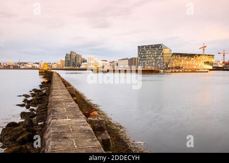 Harpa Konzerthalle und Reykjavik Waterfront warm beleuchtet durch den Sommer Mitternachtssonne Stockfoto