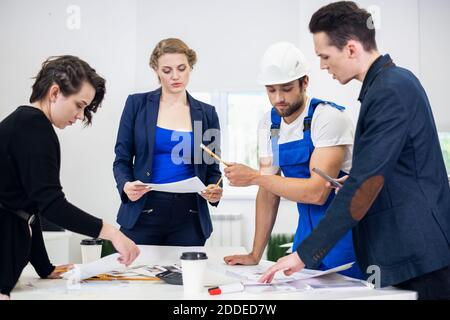 Business, Technologie und Bürokonzept, ein Team von vier Ingenieuren diskutiert ein Projekt im Büro. Stockfoto