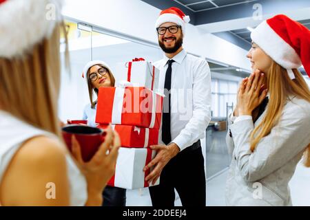 Geschäftsleute, die Weihnachtsmann-Hüte tragen, um Weihnachten zu feiern Das Büro Stockfoto