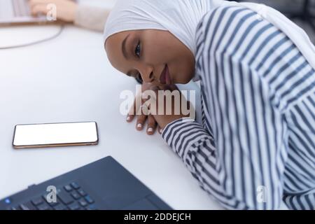 Afrikanische muslimische Geschäftsfrau Gefühl unwohl Leiden von Kopfschmerzen Migräne berühren Stirn während der Arbeit, verärgert schwarze Frau Mitarbeiter frustriert durch Stockfoto