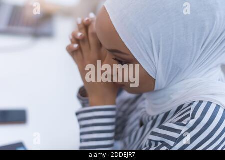 Afrikanische muslimische Geschäftsfrau Gefühl unwohl Leiden von Kopfschmerzen Migräne berühren Stirn während der Arbeit, verärgert schwarze Frau Mitarbeiter frustriert durch Stockfoto