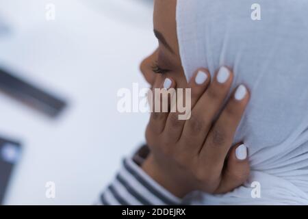 Afrikanische muslimische Geschäftsfrau Gefühl unwohl Leiden von Kopfschmerzen Migräne berühren Stirn während der Arbeit, verärgert schwarze Frau Mitarbeiter frustriert durch Stockfoto