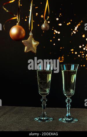 Zwei Gläser Champagner auf schwarzem Hintergrund mit weihnachtsschmuck, Nahaufnahme. Neujahrskonzept Stockfoto