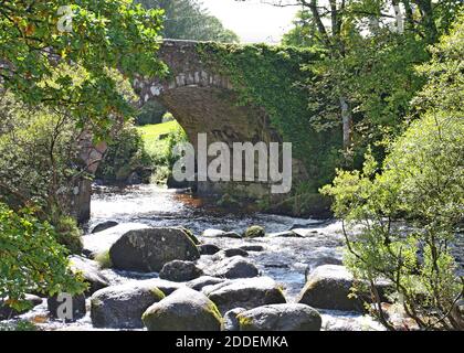 Dartmeet Straßenbrücke über den East Dart River auf Dartmoor wurde 1792 gebaut. Diese Steinbrücke ist in der Nähe einer mittelalterlichen Klappbrücke. Stockfoto