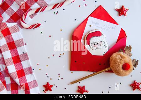 Flatlay Neujahr in weiß und rot Farben. Weihnachtskarte mit Sternen Konfetti. Ein Brief an den Weihnachtsmann mit einem Lebkuchenkekse. Hirsch-Bommel-Griff Stockfoto