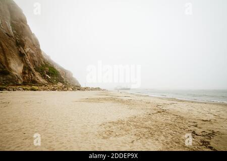 Sandstrand, Morro Rock an einem bewölkten nebligen Tag, kalifornische Küste, Morro Bay State Park Stockfoto