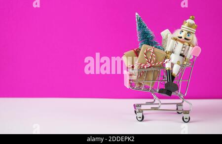 Warenkorb voller Weihnachtsgeschenke, Baum und Nussknacker Ornament. Stockfoto