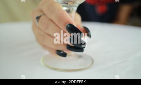 Nahaufnahme von weiblichen Händen, die ein Weinglas halten Stockfoto