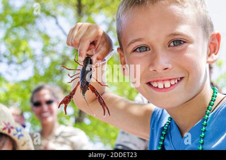 Florida Ft. Fort Lauderdale-Kajun-Zydeco-Crawfish-Festival, Feier-Messe-Ereignis Junge, der Crawdad-Mudbug-Flusskrebse hält, Stockfoto