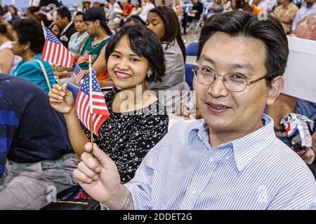 Florida, Miami Beach Convention Center, Einbürgerungszeremonie, Einwanderer mit Miniatur-US-Flagge, asiatischer Mann, männliche Frau, lächelnder neuer Bürger Stockfoto