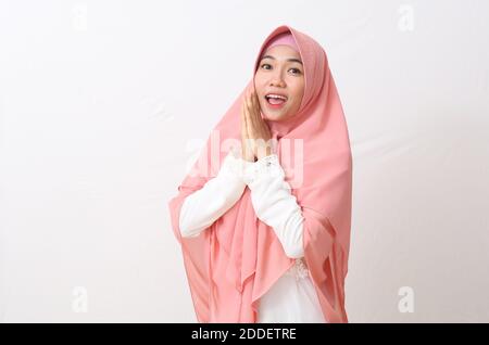 Ein Porträt einer überraschten asiatischen muslimischen Frau, die im Stehen einen Schleier oder Hijab trägt. Isoliert auf weißem Hintergrund mit Kopierbereich Stockfoto