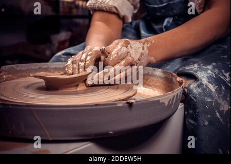 Kunsthandwerkerin Bildhauerin arbeitet mit Ton auf einem Potter-Rad und am Tisch mit den Werkzeugen. Handwerk. Nahaufnahme. Stockfoto