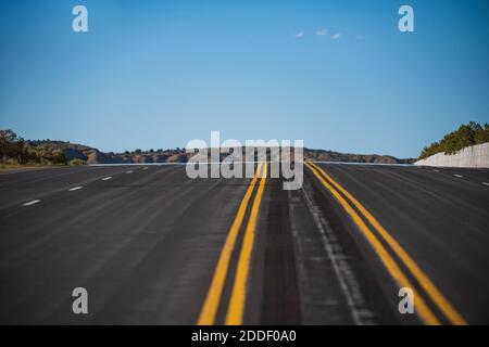 Leere Asphaltstraße und blauer Himmel. Straßenpanorama am sonnigen Sommertag. Stockfoto