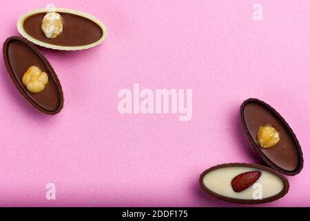 Schokolade Bonbons mit Mandeln und Haselnüssen auf rosa Hintergrund Stockfoto