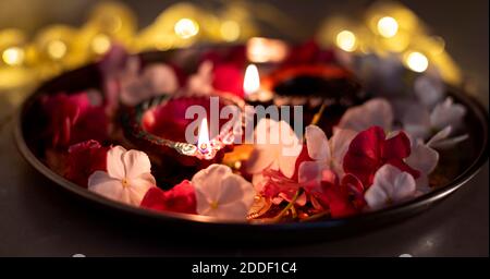 Bunte Diwali Öllampen, Deepavali Öllampen in schöner Formation mit Blumen und DIM Serienlichter in einer Bokeh-Formation beleuchtet Stockfoto