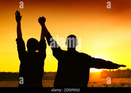 Toned Foto von Silhouette von einem zwei glückliche Freunde auf Sonnenuntergang Stockfoto