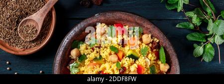 Couscous oben flach Lay Panorama mit Zutaten auf einem dunklen Holzhintergrund Stockfoto