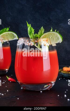 Bloody Mary Cocktail close-up, garniert mit Limette und Sellerie, auf dunklem Hintergrund Stockfoto