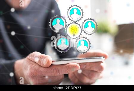Hände des Mannes hält ein Smartphone mit Teamwork Idee Konzept Stockfoto