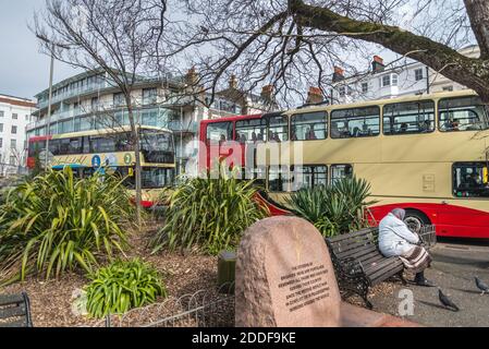 Im Stadtzentrum fahren Doppeldeckerbusse an einer stark befahrenen Kreuzung vorbei, an der sich ein Denkmal des zweiten Weltkriegs befindet, eine typische Straßenszene an einem Winternachmittag. Stockfoto