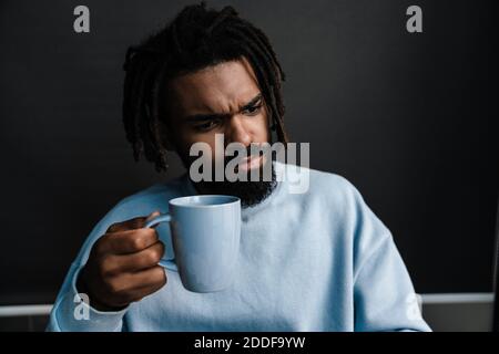 afroamerikanische schwarze ernsthafte Mann hält Tasse Kaffee zu Hause, Nahaufnahme Stockfoto