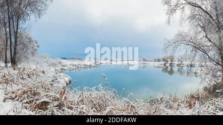 Schneebedecktes Seeufer und schöner Winterhimmel Stockfoto