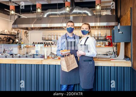 Food Delivery und to go Service Konzept aufgrund covid-19 Lockdown Notfall mit Restaurantbesitzern, die Essen zum Mitnehmen servieren Stockfoto