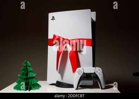 Sony PlayStation 5 Spielkonsole auf schwarzem Hintergrund. Geschenkausgabe mit rotem Band schwarz freitag und Weihnachten Deal Stockfoto
