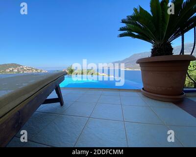 Sommerferienvilla mit schönem Infinity-Pool und tollem Panoramablick auf das Meer in isoliertem privaten Garten. Romantische Urlaubsidee für Paare Sonnendeck. Stockfoto