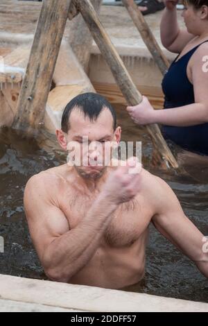 Nizhny Tagil, Russland - 19. Januar 2020: Der Mensch taucht am Dreikönigstag in kaltes Wasser des Eislochs. Traditionelles Eisschwimmen in der orthodoxen Kirche Holy Epip Stockfoto