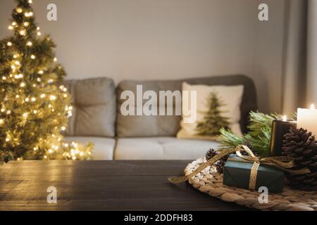 Leere Holzplatte mit Kerzen im Wohnzimmer mit Weihnachtsbaum. Weihnachten gemütlicher Urlaub zu Hause Interieur. Stockfoto