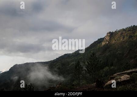 Berglandschaft an einem nebligen Tag mit Sonnenöffnungen Der Nebel hebt sich Stockfoto