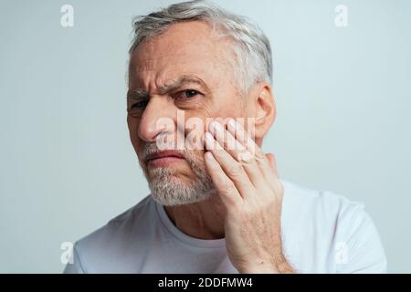Schöner Senior isoliert auf grauem Hintergrund. Konzept über das dritte Alter und die Altersgruppe Stockfoto