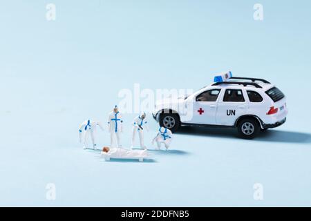 Eine Nahaufnahme von Spielzeugambulanz und Sanitätern, die einem Patienten helfen Stockfoto