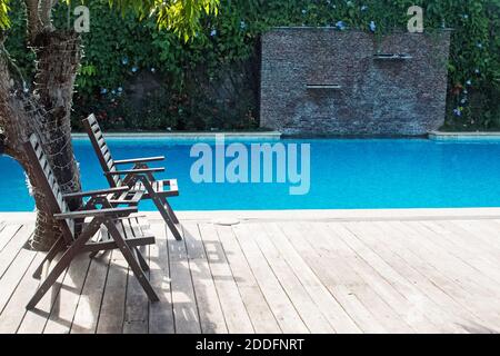 Swimmingpool mit zwei leeren Stühlen Stockfoto