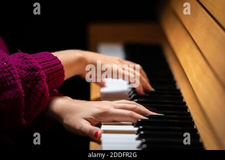 Hände eines Mädchens mit farbigen Fingernägeln spielen die Klavier Stockfoto