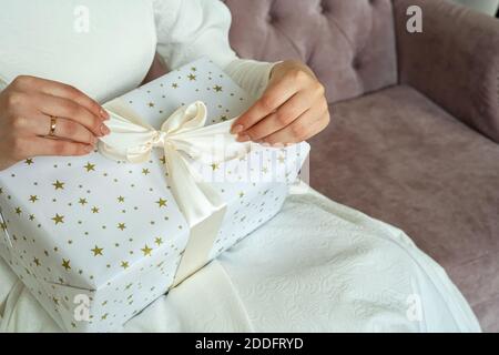 Frau verpackt weihnachtsgeschenke unter Baum Nahaufnahme. Stockfoto