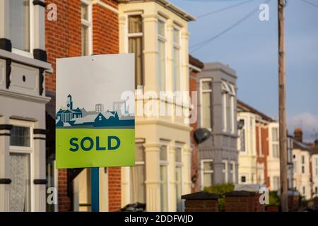 Ein Immobilienmakler verkauft Schild vor einer Reihe von Häusern Stockfoto