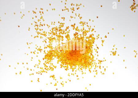 Silikagel-Trockenmittel auf weißem Hintergrund. Kleine goldene Perlen in einem Muster verteilt Stockfoto