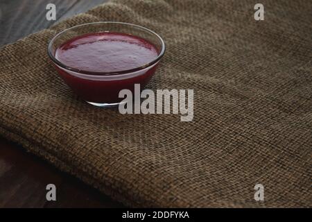 Viburnum Marmelade in Glasschale auf dem Sacktuch. Konzept des Minimalismus Stockfoto