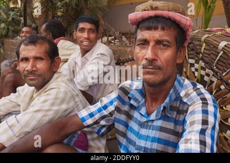 Porters in Kalbadavi Road Business Area in Mumbai, Indien, sitzen mit ihren Körben warten auf gemietet werden Stockfoto